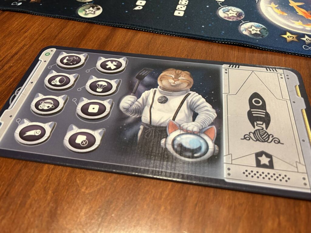 The player board holds all eight of your cats to the left side, with a portrait of a cat in the middle, and a space for points on the right.