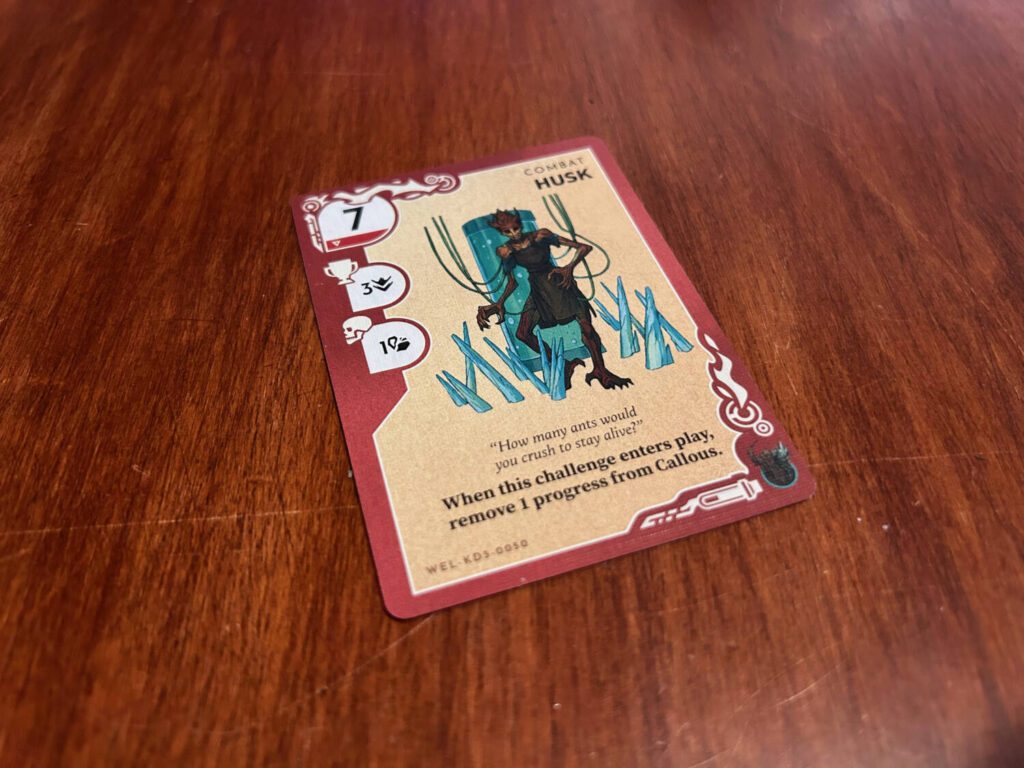 A close-up example of a Challenge card. The strength is in the upper left corner, followed by the reward for success and the penalty for failure. Bold text at the bottom of the card indicates that the card has a static effect.