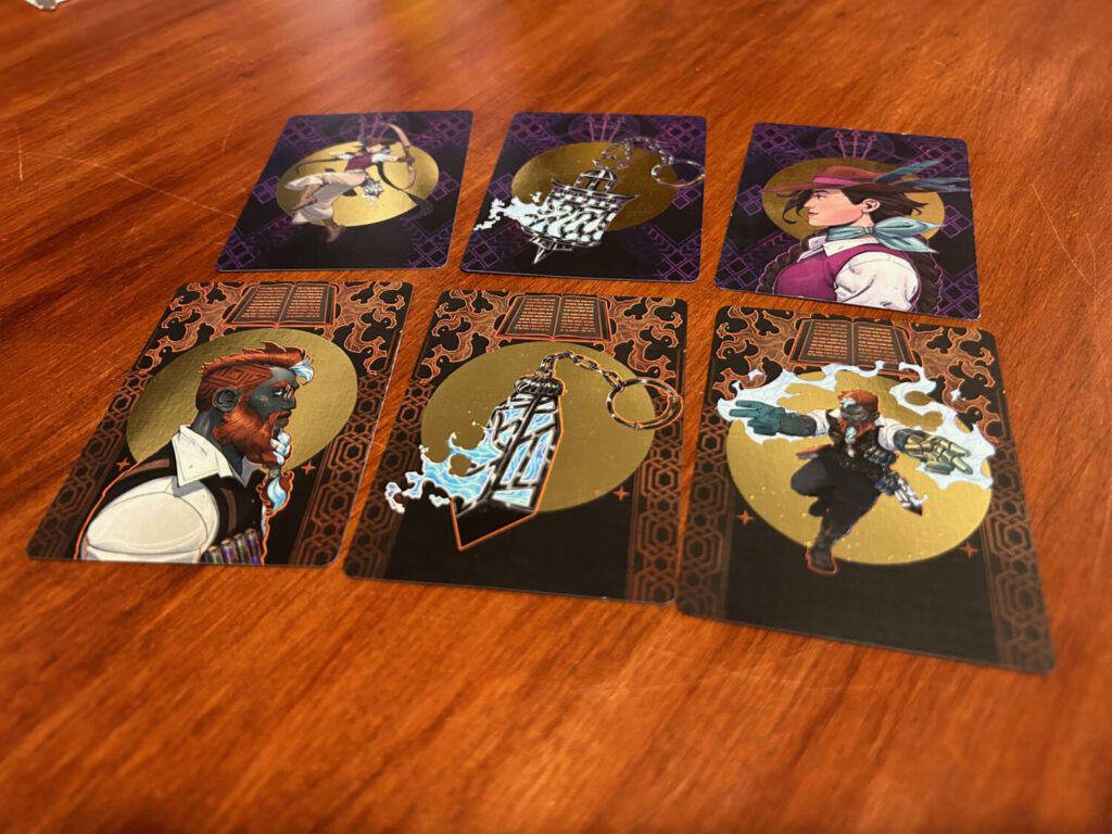The backs of the player decks use gold spot-foiling and vibrant illustrations.