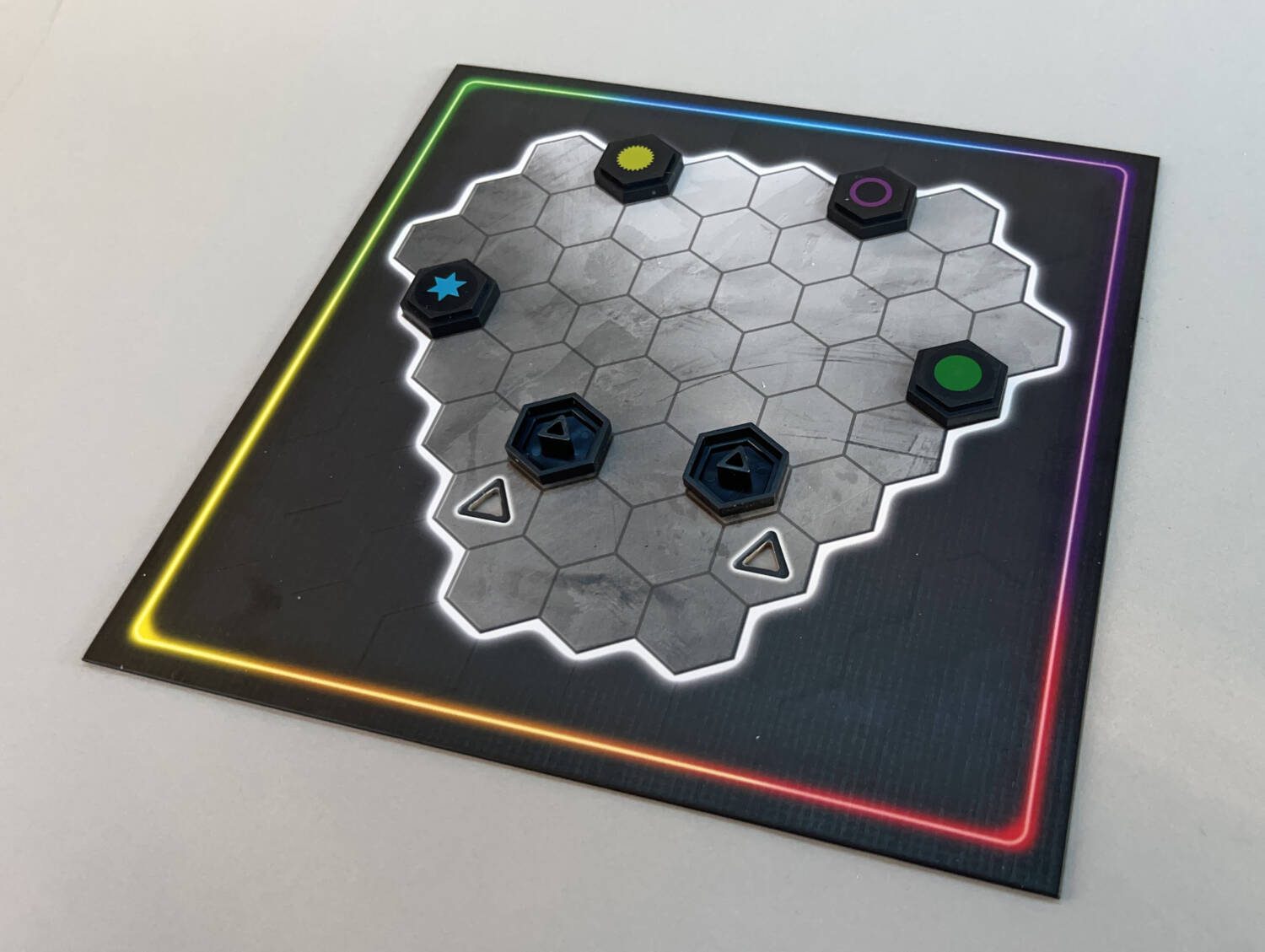 Randomly setting up the single hex starting pieces. Note the triangular cut out in the board that matches the underside of the starting pieces turned upside down.