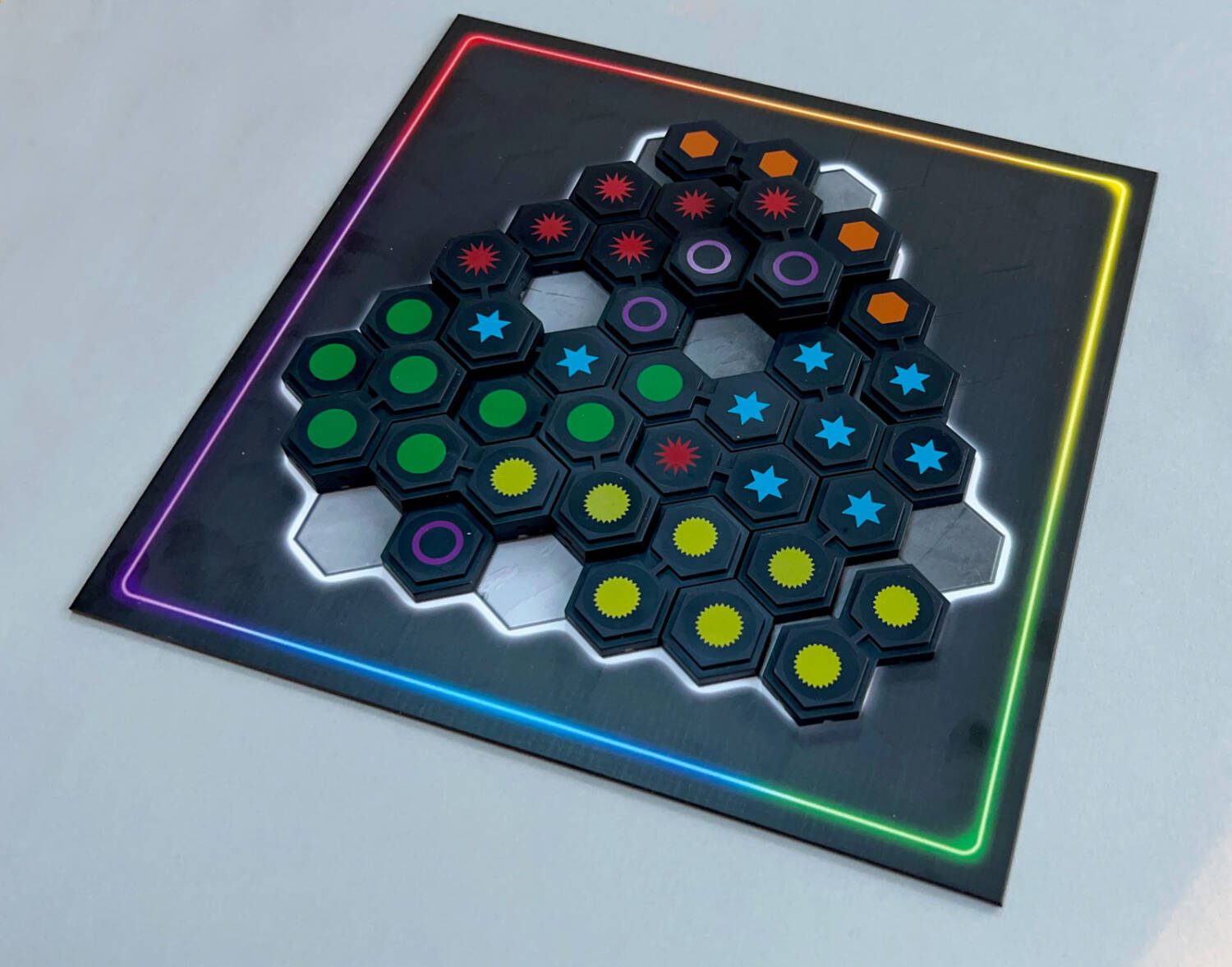 Each of the exposed gray hexes here are on the bottom level of the board and, therefore, are 'holes'. You cannot play a piece over a hole, so you must play around them. Note the lone purple circle in the lower left edge of the board. With two board-level holes on either side and the tiles behind it already built up to the second level, it, too, is a hole.