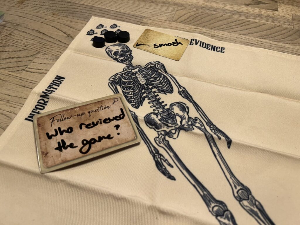 A cloth board with a skeleton printed on it. Dry erase cards are on various parts of the board.