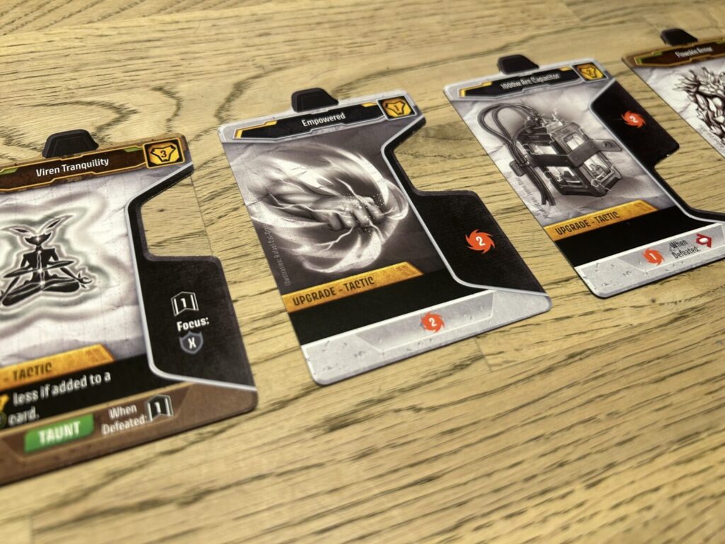 A row of upgrade cards on a wooden table.