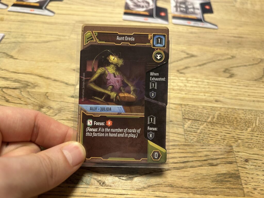 The same Ally card as before, but the notch has been filled in with icons from two Upgrade cards.