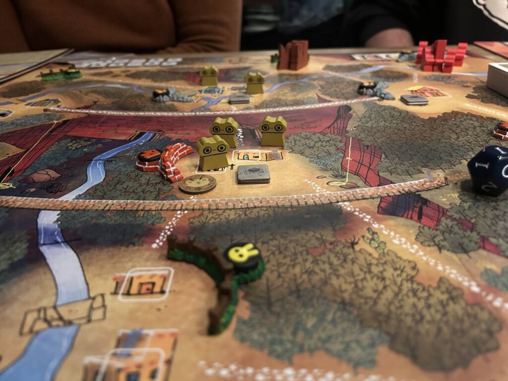 Three frog meeples stand in a clearing in the center of the Gorge Map.