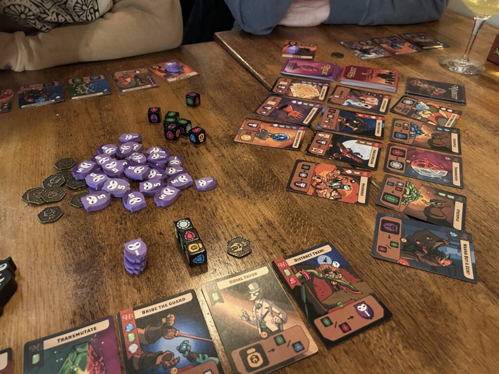 Another photo of a full table of cards, dice, and wooden owls.