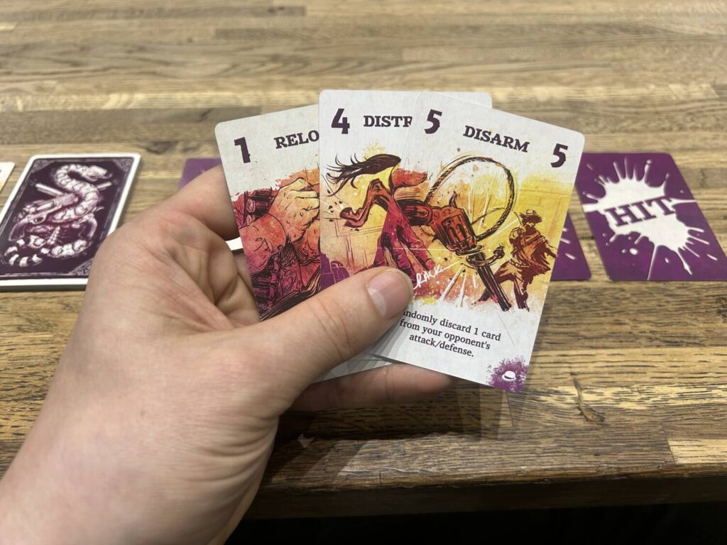 A hand holding three cards, numbered 1, 4, and 5. Each card has an illustration across the center, with several lines of text at the bottom.