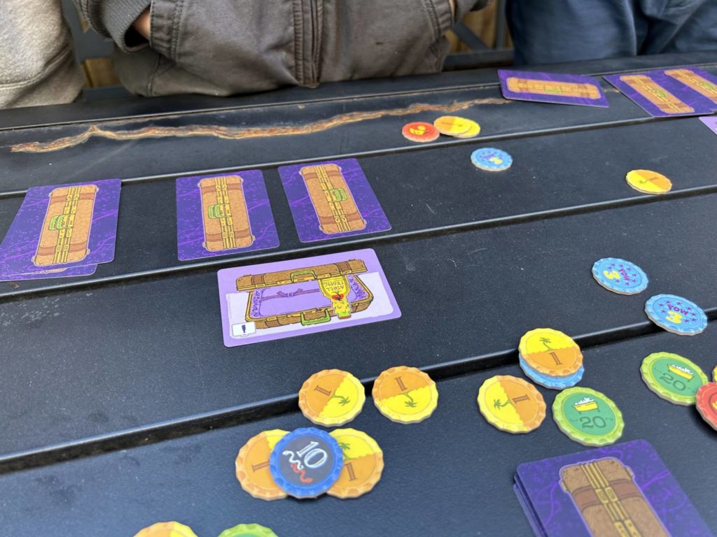 Three cards played out on the tale. Two, the facedown cards, stand tall, like pillars, while a third card sits above them, sideways and open.