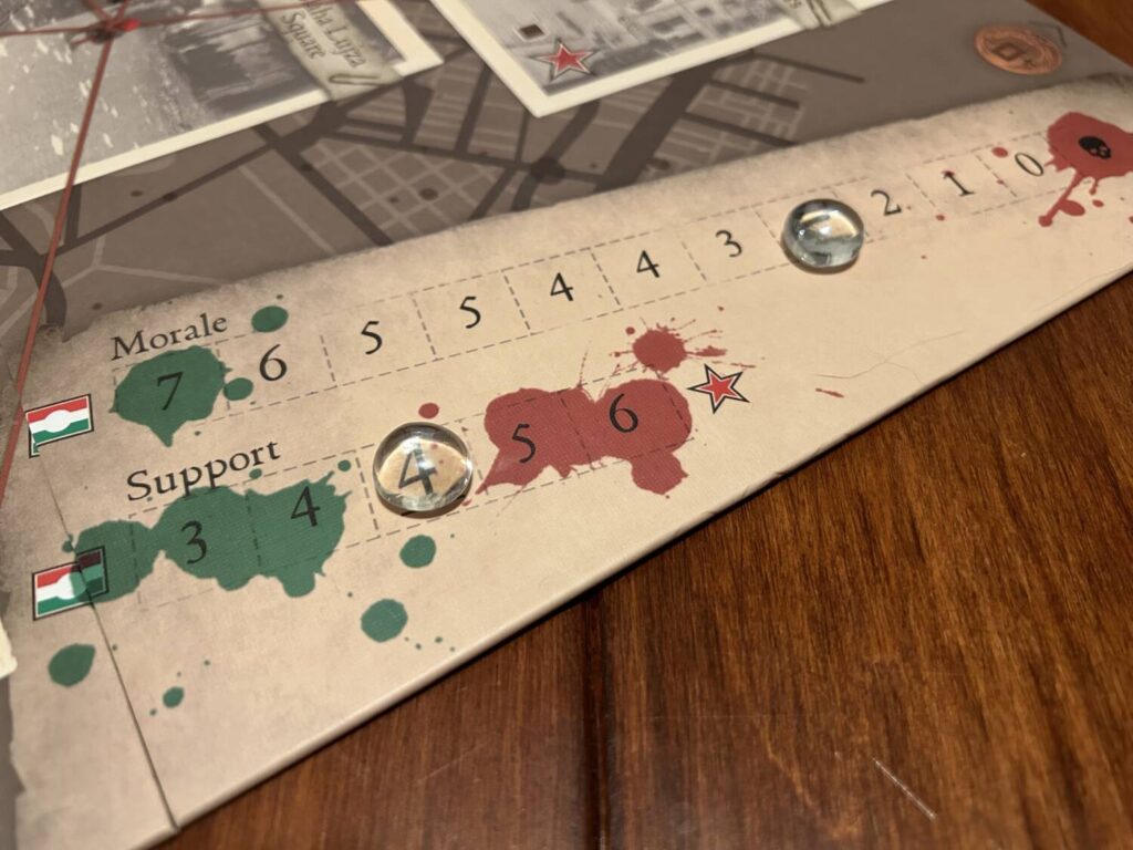 There are two tracks on the board, for Morale and Support, each of which is marked with a cute li'l glass bead.