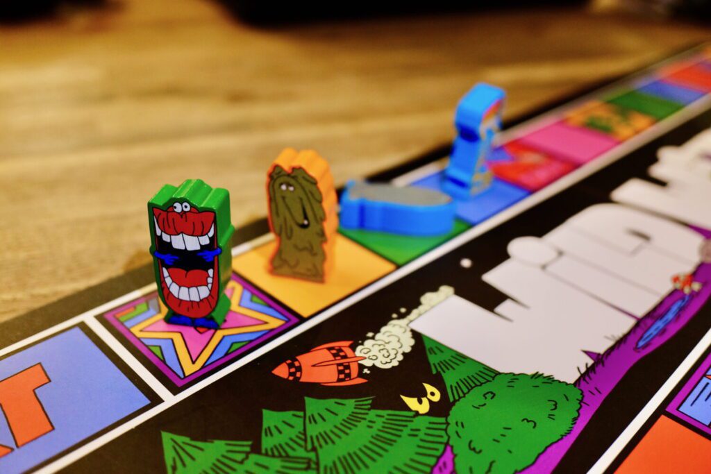 A series of brightly-illustrated characters on the race track. One is tipped over.