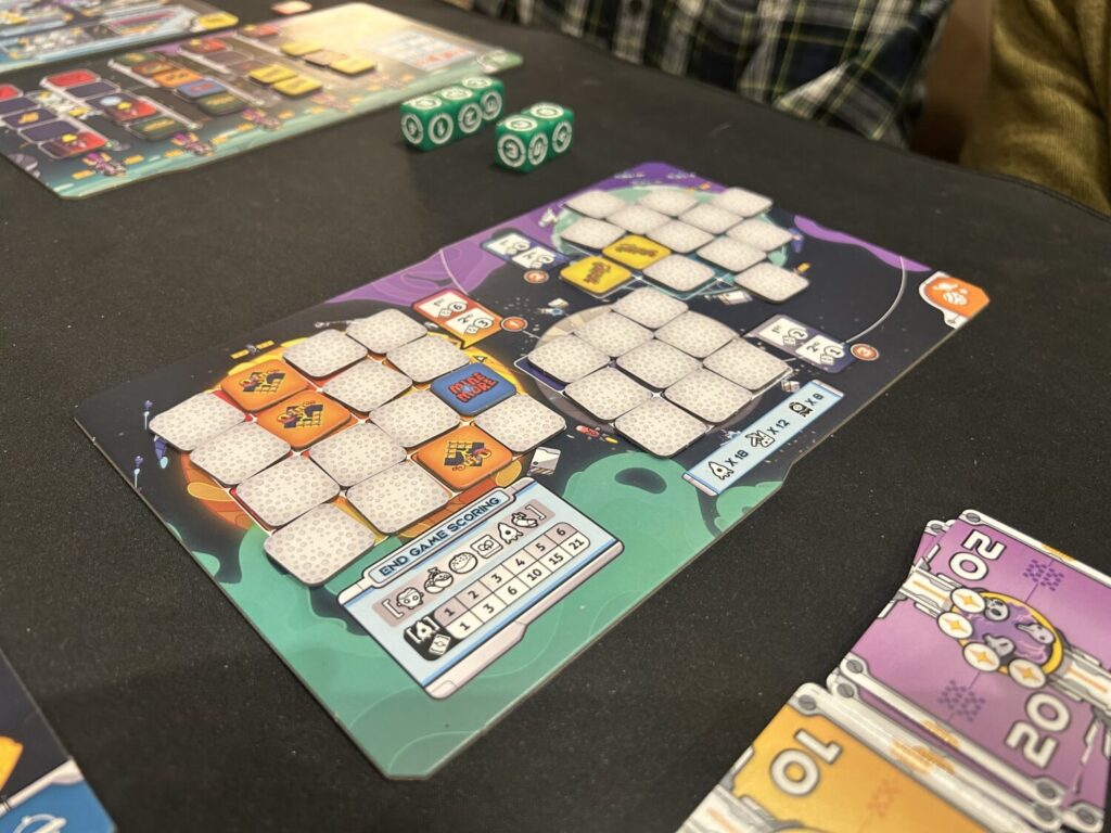A board with three planets, each covered in mostly facedown square tokens.
