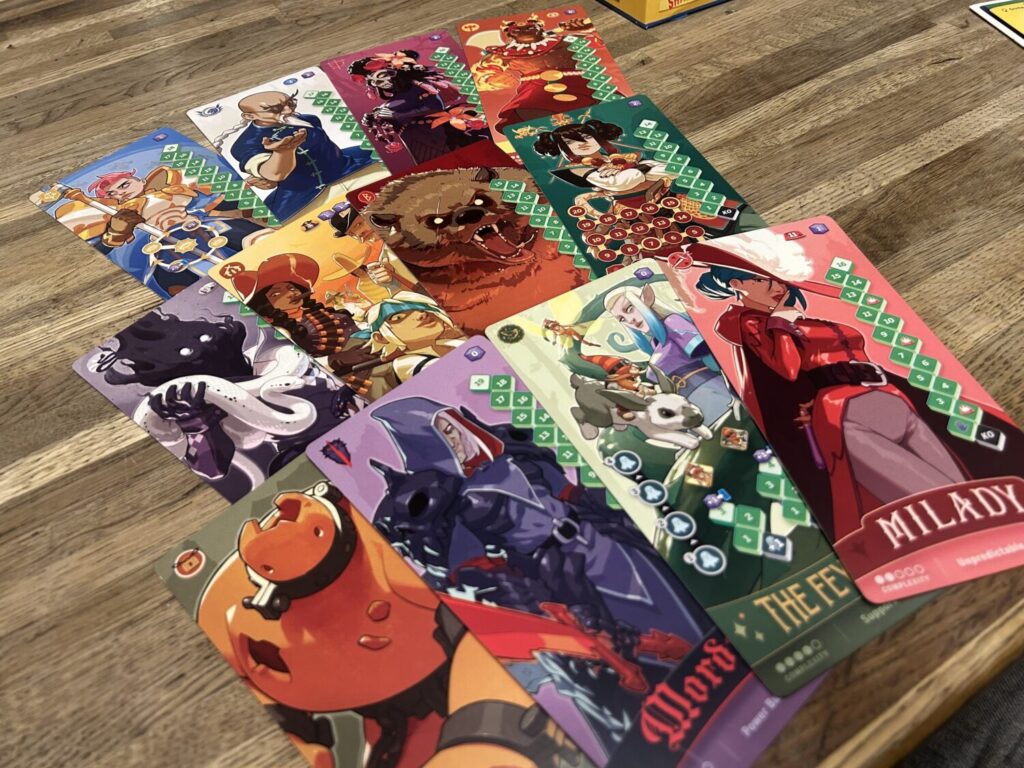 A smattering of character cards spread out on a wooden table.