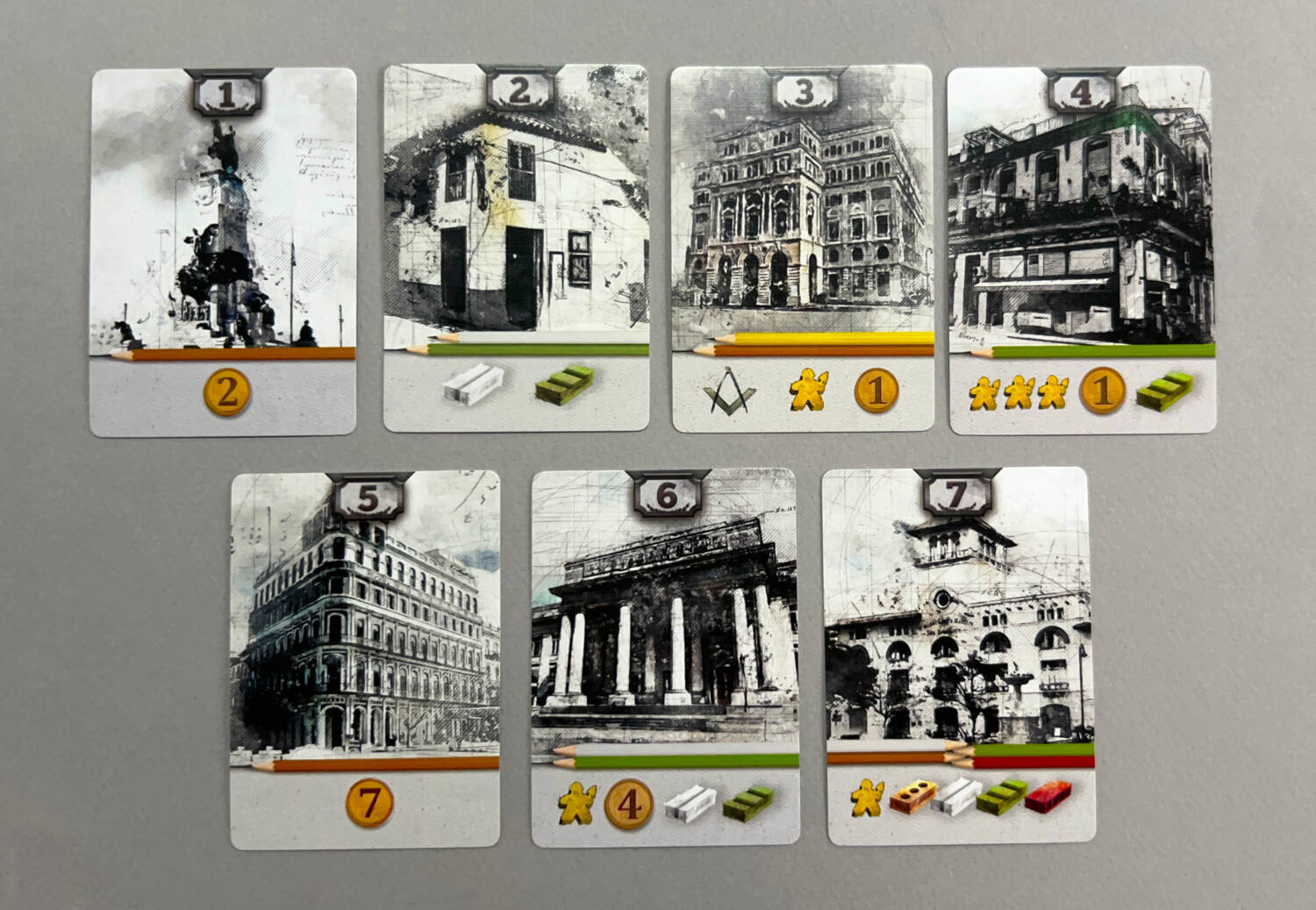 Examples of buildings in La Habana. The more items listed at the bottom of the card, the harder it will be to 'purchase' the card--but they also increase the number of points the card is worth.