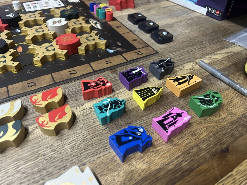 A group of wooden Deities sit on a wooden table.